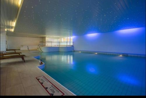 una gran piscina con una pared azul en Studio en Zúrich