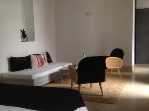 a living room with a couch and a table and chairs at Riad Yamcha in Meknès