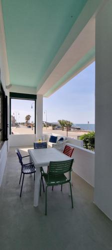einen Tisch und Stühle auf einer Terrasse mit Blick auf den Strand in der Unterkunft Casa Cristina in Torre Canne
