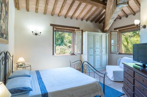 a bedroom with a bed and a tv at Casale Dalmanuta in San Venanzo
