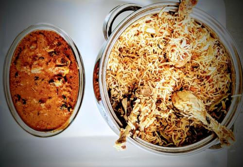 a pot of food and a bowl of spaghetti at Hotel Menaka in Vijayawāda