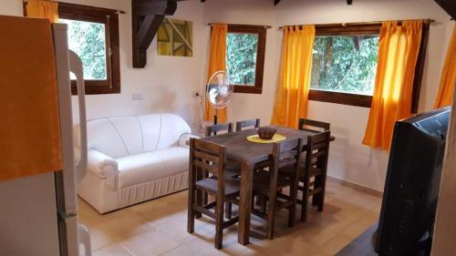 sala de estar con mesa y sofá blanco en Magma Village en Los Reartes