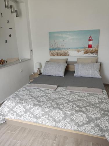 a bedroom with two beds and a painting of a lighthouse at Ioanna Studio Διαμέρισμα κοντά στη θάλασσα. in Kolimbia