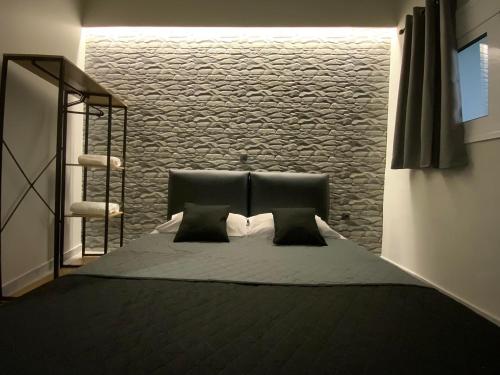 a bedroom with a black bed with two pillows at I Love Home Mini in Kalamata