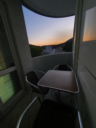 a table and chairs in a room with a window at Apartmani Matković in Sutomore