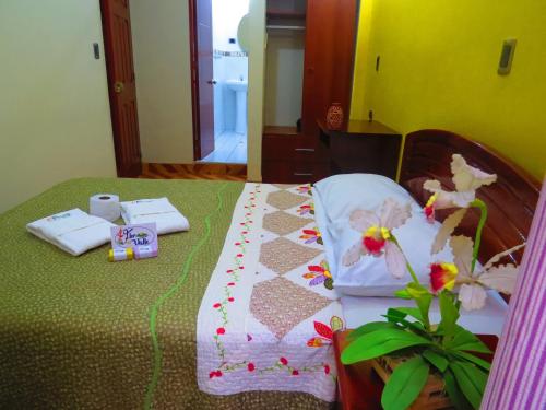 a bed with a quilt on top of it at Flor del Valle Posada in Tarapoto