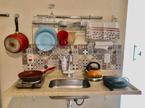 伊塔卡雷的住宿－Portal Mágico，厨房柜台配有水槽和餐具
