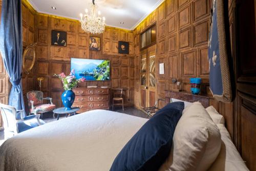 um quarto com paredes com painéis de madeira e uma cama. em La Suite des Consuls em Sévérac d' Aveyron