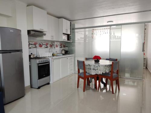 a kitchen with a table and chairs and a refrigerator at MINI DEPARTAMENTO LAS VEGAS in Chimbote