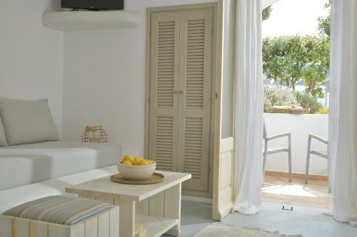 a living room with a table with a bowl of fruit on it at Hotel Mediterranean in Stelida