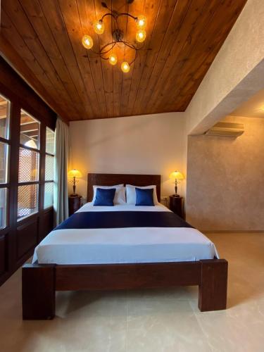 a bedroom with a large bed with a wooden ceiling at S.Nikolis' Historic Boutique Hotel in Rhodes Town