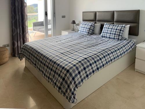 a bedroom with a bed with a checkered blanket at Appartement du Bonheur in La Cala de Mijas