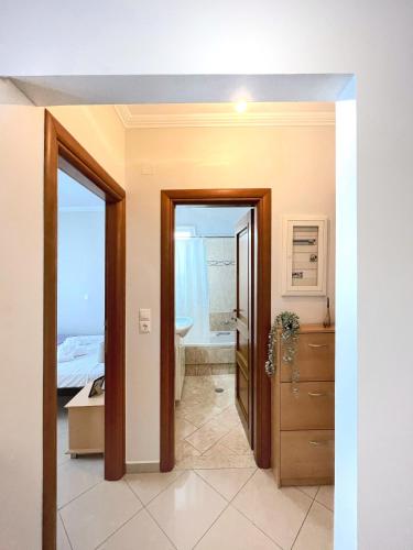 a bathroom with a door leading to a bedroom at URBAN APARTMENT in Lefkada