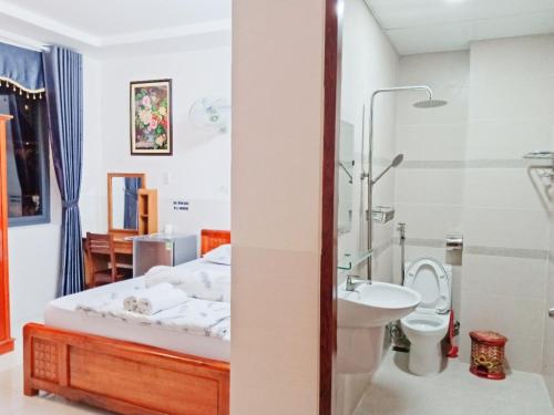 una camera con letto, lavandino e servizi igienici di Minh Quân hotel a Vung Tau