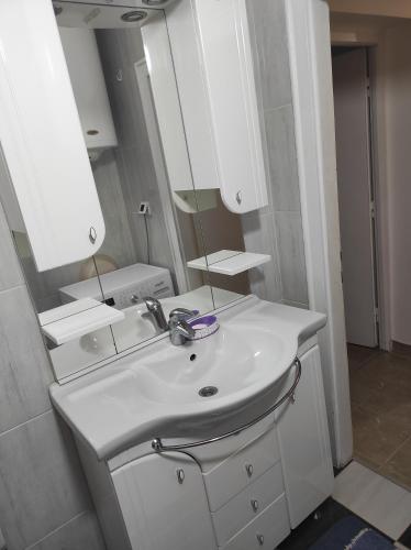 a bathroom with a white sink and a mirror at Emerald Suite in Valjevo