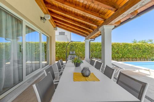 a patio with a table and chairs and a pool at Villa Sana in Selina