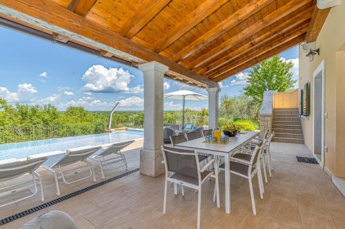 a patio with a table and chairs and a pool at Villa Sana in Selina