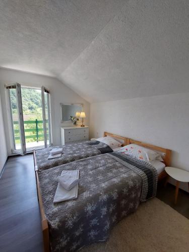a bedroom with a large bed and a large window at La Reina Una in Bihać