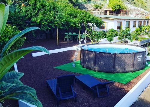 einen Pool mit zwei Stühlen und einer Schaukel in der Unterkunft Los Huertos Conect with the nature & relax in Icod de los Vinos