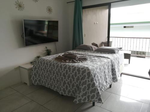 a bedroom with a bed with a blanket on it at Hotel Cabinas el Tecal in Uvita