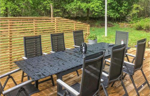 a black table and chairs on a wooden deck at 3 Bedroom Awesome Home In Västra Torup in Västra Torup