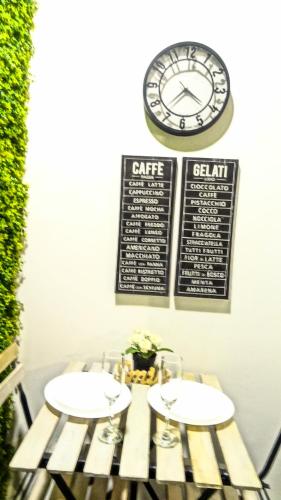 a table with two chairs and a clock on the wall at Cozy Rooms - BAÑERA HIDROMASAJE in Valencia