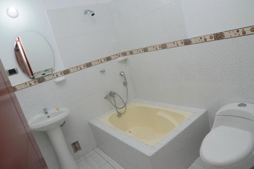 y baño con bañera, aseo y lavamanos. en Flor del Valle en Tarapoto