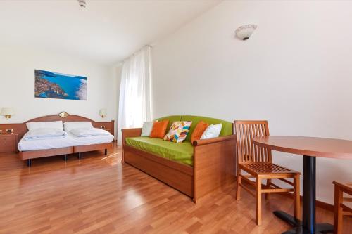 a living room with a couch and a table at Beach Hotel Rosa in Malcesine