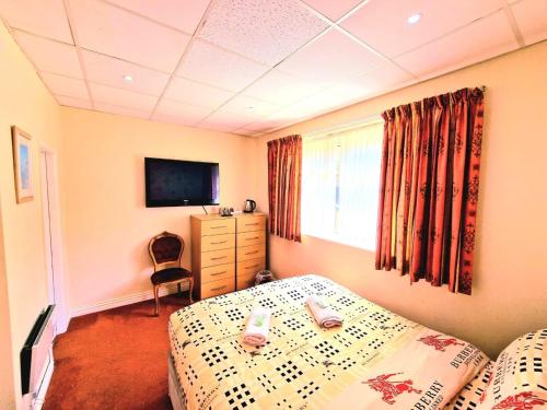a bedroom with two beds and a television in it at The Albany hotel in Blackpool