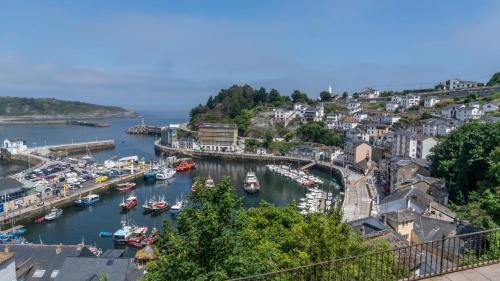 a harbor with boats in the water in a town at Apartamentos Mar y Sol in Luarca