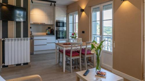 Apartamentos Mar y Sol في لواركا: مطبخ وغرفة طعام مع طاولة وكراسي