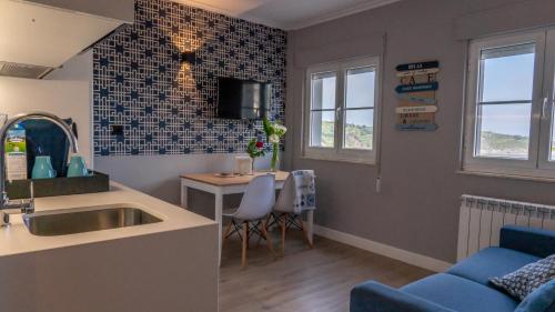 a kitchen and living room with a sink and a table at Apartamentos Mar y Sol in Luarca