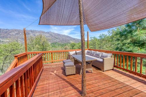 a patio with a couch and an umbrella on a deck at Cascadel Haven in North Fork