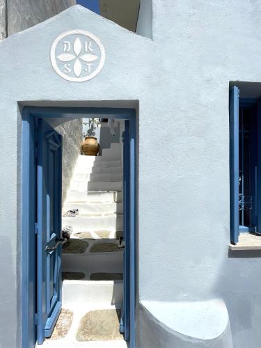 an entrance to a white building with a blue door at Little Symi House in Symi