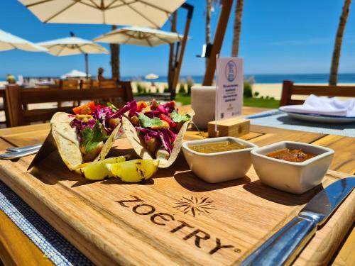 een houten snijplank met taco's en salsa op een tafel bij Zoetry Casa del Mar Los Cabos in Cabo San Lucas