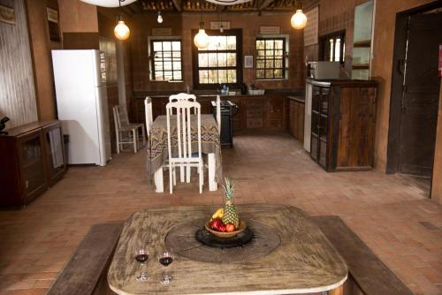 una cocina con una mesa con una piña. en Pousada La Creación, en Praia do Rosa