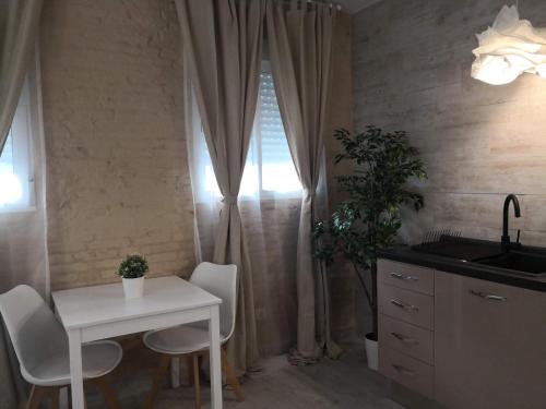 a kitchen with a white table and chairs and a sink at Cozy Rooms - BAÑERA HIDROMASAJE in Valencia