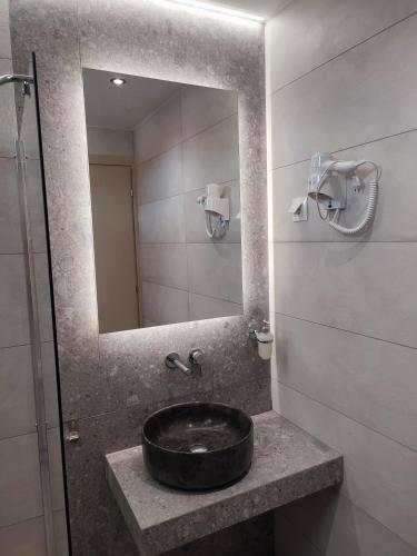 a bathroom with a sink and a mirror at Hotel Paraktio in Nea Kalikratia