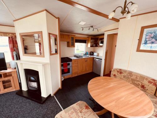 a living room with a table and a kitchen at Fantasy Island Caravan Hire- Located at Fantasy Island- Eastgate Caravan Park, Sea Lane, Ingoldmells in Ingoldmells