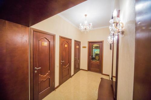 a hallway with wooden doors and a chandelier at Fenix in Vinnytsya
