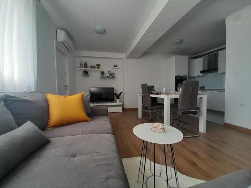 ein Wohnzimmer mit einem Sofa und einem Tisch in der Unterkunft Apartment Karlito in Omiš