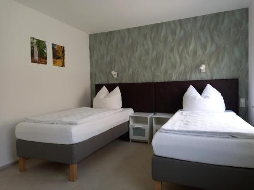 sypialnia z 2 łóżkami z białą pościelą w obiekcie Gästewohnung Meyer w mieście Seehausen
