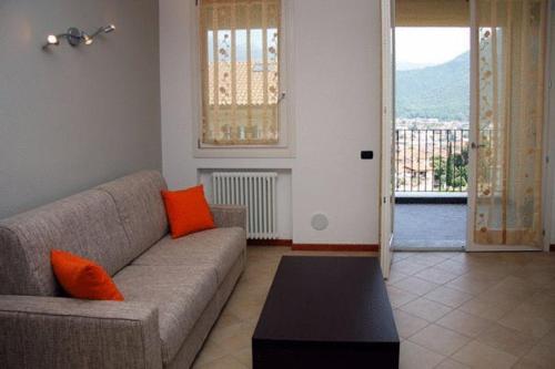 a living room with a couch with orange pillows at COZY LAKE COMO APARTMENTS in Valmadrera
