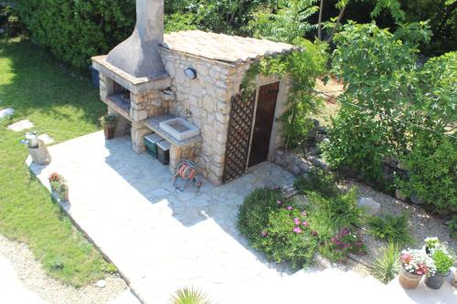 a small house with a fireplace in a garden at Villa Calma, recharge your body and mind in Gabonjin