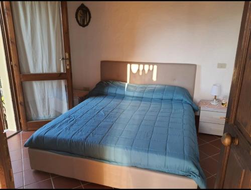 a bedroom with a bed with a blue comforter at Garova in Porto Istana