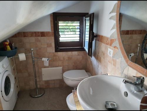 a bathroom with a toilet and a sink and a mirror at Garova in Porto Istana