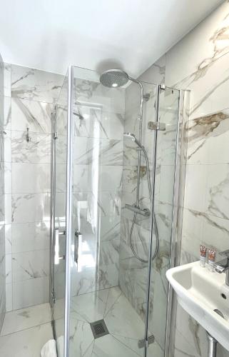a bathroom with a shower and a sink at Hotel Normandy in Cap d'Ail
