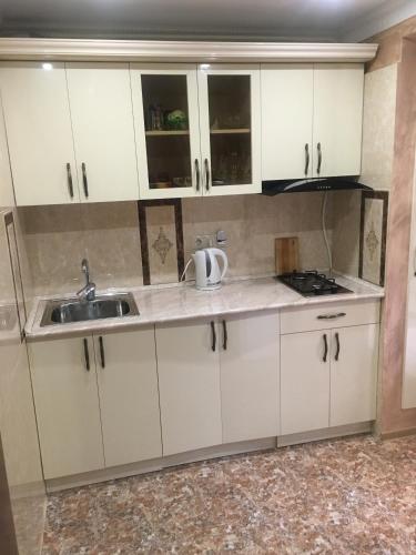 una cucina con mobili bianchi e un lavandino di DILIJAN Apartment a Dilijan