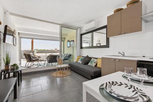 une cuisine et un salon avec un canapé et une table dans l'établissement Sud coursive naturiste, au Cap d'Agde