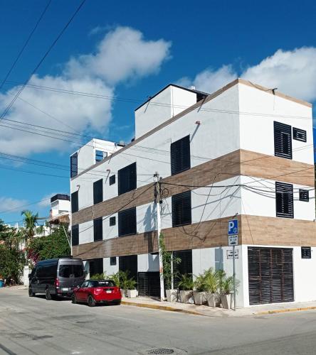 un edificio en una calle con coches aparcados delante en Casa Fausta by Sail, en Playa del Carmen